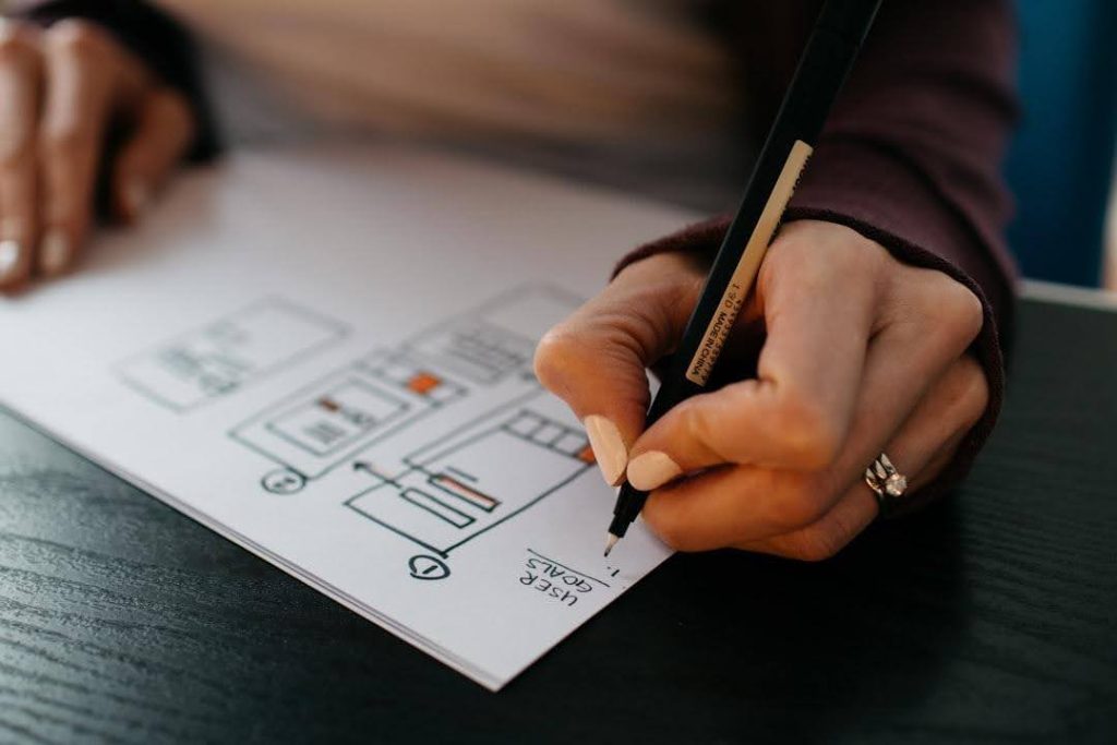 Person writing down the website plan